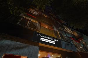 a tall building with a sign on the side of it at Super Townhouse Oak Indiranagar in Bengaluru