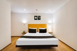a bedroom with a large bed in a room at Super Townhouse Oak Indiranagar in Bengaluru