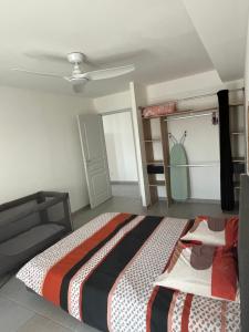 a bedroom with a bed and a ceiling fan at Résidence Le Carillon in Saint-André