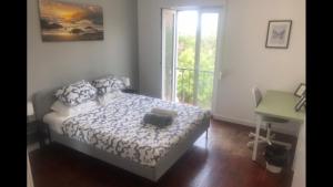 ein Schlafzimmer mit Bett, Schreibtisch und Fenster in der Unterkunft Sea Breeze Apartment in Lagos