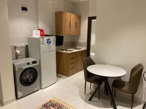 una cucina con un tavolo e una lavatrice e un tavolo e sedie di شقة فاخرة غرفة ماستر وصالة مريحة a Medina
