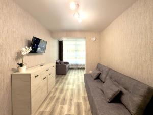 Una sala de estar con un sofá y un televisor. en new apartment near the center квартира в новому будинку поруч з центром, en Sumy