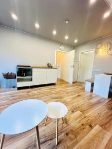 a living room with two tables and a kitchen at Ferienwohnung Prieros am Langer See mit Klima in Heidesee