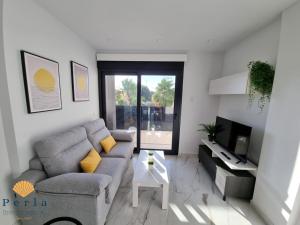 ein Wohnzimmer mit Sofa und Fernseher in der Unterkunft Perla Holidays - Stunning apartment in Los Altos in Orihuela