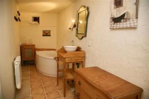 une salle de bain avec une baignoire et un lavabo et une baignoire dans l'établissement Gîte La Grimaudière, à Rochetoirin 3 autres photos