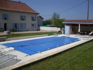 une grande piscine bleue dans une cour dans l'établissement Gîte La Grimaudière, à Rochetoirin