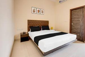 a bedroom with a large bed in a room at Super Townhouse HBR Layout in Bengaluru