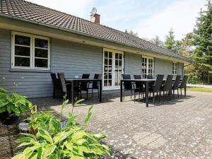 a patio with a table and chairs in front of a house at 12 person holiday home in Hals in Hals