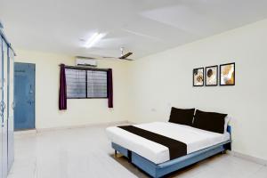 a bedroom with a bed in a white room at Hotel O Talawade IT Park Formerly AR Rooms in Dehu