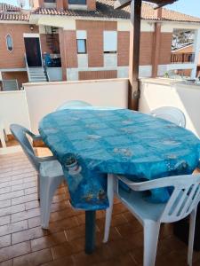 a table and chairs on a balcony with an umbrella at Casa vacanza Roby in Lido dei Pini