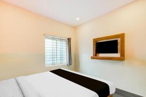 una camera da letto con un letto e una TV a parete di Super Collection O Dilsukhnagar Metro Station Formerly Hotel Simra Relax Inn a Hyderabad