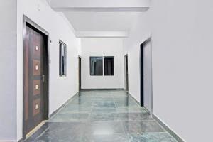 an empty corridor with white walls and a door at Super Hotel O Santragachi Junction Formerly Hotel Shubra in Kolkata