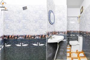 a bathroom with a wall mural of swans at Super Hotel O Santragachi Junction Formerly Hotel Shubra in Kolkata