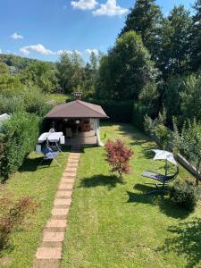 un gazebo con tavolo e panca in un cortile di Casa Linda a Curtea de Argeş Altre 10 foto