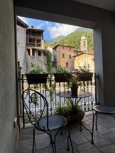 a balcony with two tables and chairs on a balcony at Casa vacanze Borgo Grigna in Primaluna
