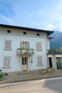 a white house with windows and a balcony at Casa vacanze Borgo Grigna in Primaluna +2 photos
