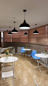 a dining room with tables and chairs and lights at Baiterek Premium in Astana
