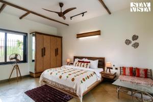 Un dormitorio con una cama y una mesa y una ventana. en StayVista at Rustic Roots with Bonfire, Lawn, en Jaipur 19 fotos más