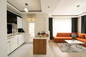 a living room with an orange couch and a kitchen at ARGEUS PRESTİJ in Kayseri