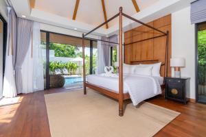 - une chambre avec un lit à baldaquin et une piscine dans l'établissement Anchan Villas Phuket - Private 2 Bedroom Pool Villas by Escape Villas, à Ban Phru Champa 21 autres photos