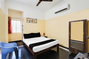ein Schlafzimmer mit einem Bett und einem blauen Stuhl in der Unterkunft Super Hotel O Karakambadi Road Near Leela Mahal Circle in Tirupati
