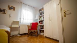 a room with a book shelf with a red chair at Chalet Lana with Hot Tub in Gozd Martuljek