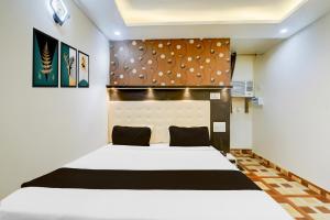 a bedroom with a white bed in a room at Super Collection O Jagdeo Path Patna in Patna