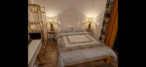 a small bedroom with a bed and two lamps at Jeleni Ruczaj in Karpacz