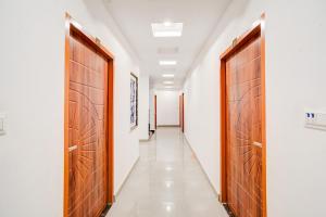 a corridor with two wooden doors and a long hallway at Hotel O Sunrakh Road Vrindavan Formerly Ganga Residency in Vrindāvan