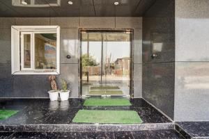 a lobby with a glass door and green floors at Hotel O Sunrakh Road Vrindavan Formerly Ganga Residency in Vrindāvan
