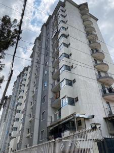 a tall apartment building with balconies on it at Cozy & Modern One Bedroom Opposite Garden City Mall in Nairobi
