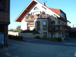 ein großes weißes Haus mit Balkon auf einer Straße in der Unterkunft Gästehaus Jüngling in Kottenborn