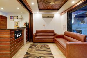 a waiting room with a leather couch and chair at Super Townhouse Arcot Road Near Kauvery hospital in Chennai