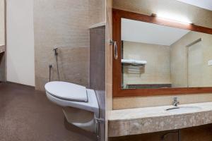 a bathroom with a toilet and a mirror at Super Townhouse Arcot Road Near Kauvery hospital in Chennai +66 photos