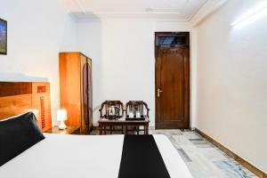 une chambre avec un lit, une table et des chaises dans l'établissement Super Hotel O Paharganj Near Railway Station Formerly Chand Palace, à New Delhi