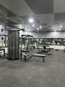a gym with benches and machines in a room at LYO guest house Dubai marina BEDSPACE in Dubai