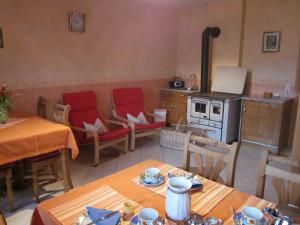 uma cozinha com uma mesa, cadeiras e um fogão em Gästehaus Jüngling em Kottenborn