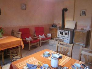 eine Küche mit einem Tisch, Stühlen und einem Herd in der Unterkunft Gästehaus Jüngling in Kottenborn