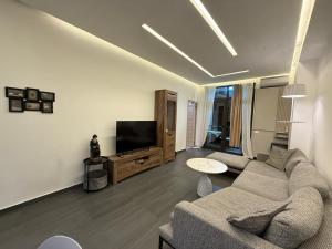 a living room with a couch and a flat screen tv at Stylish 2BR Apartment with Balcony by Republic Square - City Center I Стильные апартаменты с 2 спальнями и балконом у площади Республики-Центр Города in Yerevan