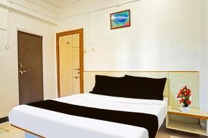 a bedroom with a large bed in a room at Super Collection O Pune Nagar Road Viman Nagar Formerly Ananta Sagar in Pune