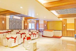 a banquet hall with white chairs and a stage at Super Collection O Pune Nagar Road Viman Nagar Formerly Ananta Sagar in Pune