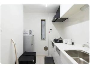 eine weiße Küche mit Spüle und Herd in der Unterkunft Hotel chen's house - Vacation STAY 42508v in Tokio + 49 Fotos