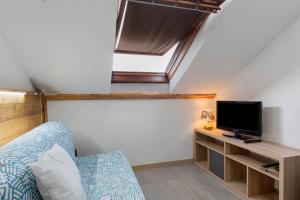 格雷桑Il Nido Di Montagna的一间有床、电视和窗户的房间