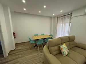 a living room with a couch and a table and chairs at Alamos Suite a 150m de la catedral in Jaén
