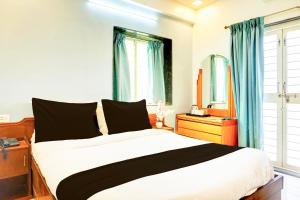 a bedroom with a large bed and a mirror at Super Collection O Ubale Nagar in Pune +54 photos