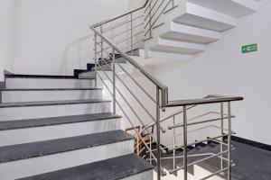 a staircase in a building with a metal railing at Super Hotel O Anayara Near Lulu Mall Formerly Timber Residency in Trivandrum +40 photos