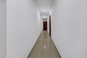 a hallway with white walls and a long corridor at Super Hotel O Anayara Near Lulu Mall Formerly Timber Residency in Trivandrum