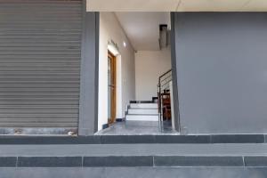 a hallway of a building with stairs and a door at Super Hotel O Anayara Near Lulu Mall Formerly Timber Residency in Trivandrum