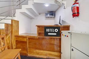 a kitchen with a desk and a refrigerator at Super Hotel O Anayara Near Lulu Mall Formerly Timber Residency in Trivandrum