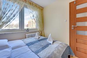 a bedroom with a bed and a window at Cozy Amber in Gdańsk